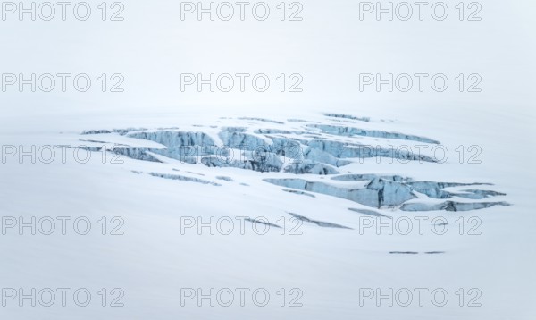 Smooth white snowy area on the glacier broken by crevasses with blue rugged glacial ice, detail, Exit Glacier, Kenai Peninsula, Alaska, USA