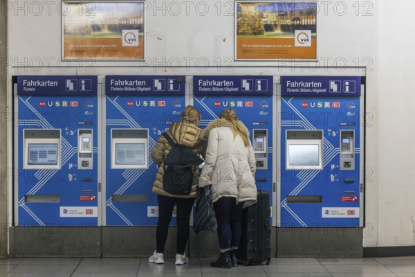 Ticket vending machine at Stuttgart Airport with travelers buying a public transport ticket. Stuttgart, Baden-Württemberg, Germany