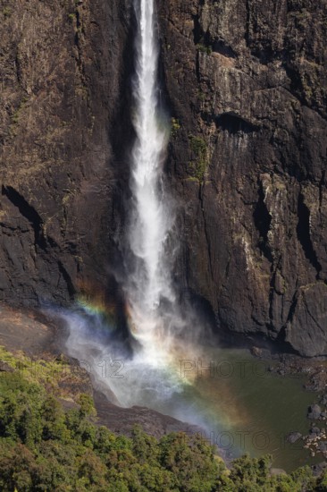 Daytime top view at Wallaman Falls with rainbow in mist over cascading water, Queensland, Australia