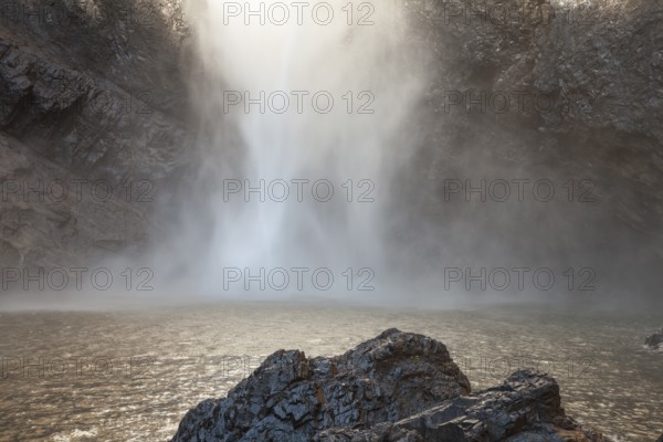 Daytime view from below of Wallaman Falls cascading into a rainforest gorge, Queensland, Australia