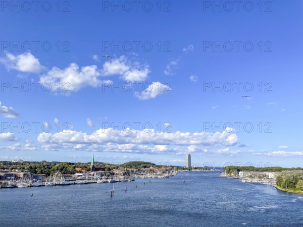 View over the Trave towards the mouth in the underground, the church of Travemünde and the Atlantic Hotel, with clouds and birds, Travemünde, Lübeck, Schleswig-Holstein, Germany