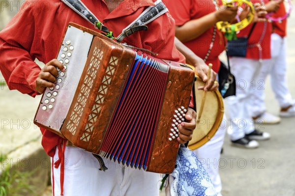 Accordion player with his instrument during a Congado religious festival in the state of Minas Gerais, Minas Gerais, Brazil