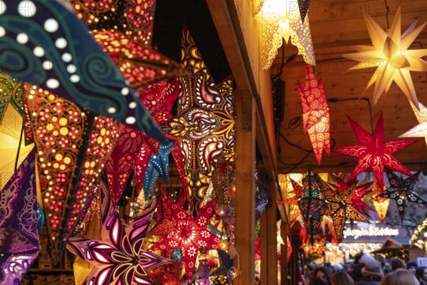 December 22, 2025, many glowing Christmas stars hanging at a marke t stall near St. Paul's Church, Frankfurt, Hesse, Germany