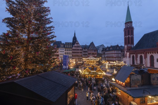 December 22, 2025, View from a window inside the Roemer looking down at the Frankfurt Christmas Market on Roemerberg at twilight. Festive lights and stalls fill the historic square below, Frankfurt, Hesse, Germany