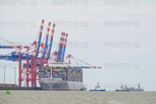 The container ship OOCL Germany with 59 m width and 400 m length of one of the largest container ships in the world is unloaded at the container bridges in Jade Weser Port, Wilhelmshafen, Jade Bay, Lower Saxony, Germany