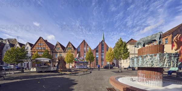 Pastor sin Kauh fountain, bronze sculpture, sculptor Stephan Horota, historic half-timbered houses, brick buildings, building material brick, trees, autumn leaves, beer cars, sales cars, pedestrians as accessories, blue sky, altocumulus clouds, slaughtermarket, Schwerin, state capital, district-free city, Mecklenburg-Western Pomerania, Germany
