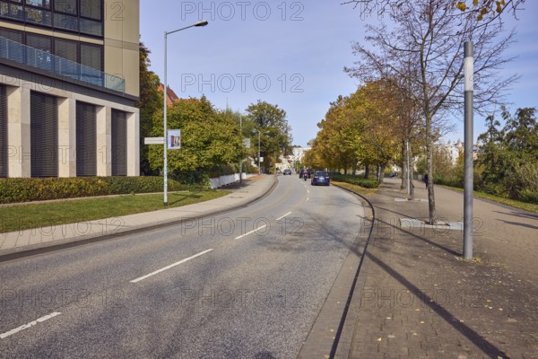 General architecture, modern buildings, pavement made of concrete paving stones, road made of asphalt, lantern, central strip, trees with autumn leaves, hedge, meadow, blue sky, cirrostratus clouds, Graf-Schack-Allee, Schwerin, state capital, district-free city, Mecklenburg-Western Pomerania, Germany