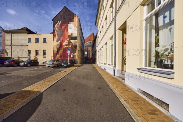 Residential buildings, apartment buildings, modern façade painting, houses, façade with windows, downpipe and stairs, brick sidewalk, asphalt road, parking lot with cars, blue sky, altocumulus clouds, Domstraße, Schwerin, state capital, district-free city, Mecklenburg-Western Pomerania, Germany