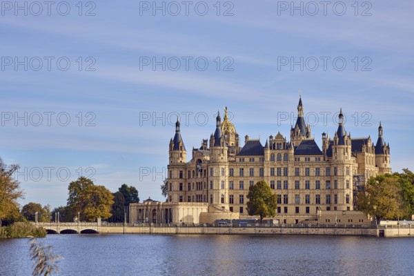 Castle, Burgsee lake, trees, bushes, car bridge and footbridge, water surface with small waves, blue sky, cumulus clouds, cirrostratus clouds, Schwerin, state capital, district-free city, Mecklenburg-Western Pomerania, Germany