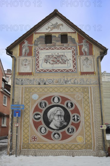 House with historical wall by artist group Kollektiv K 2020, historical paintings on the city's history, contemporary history, house façade, street art, mural, head, square, pipe, city fire, eel, Swabian Jura, Baden-Württemberg, Germany