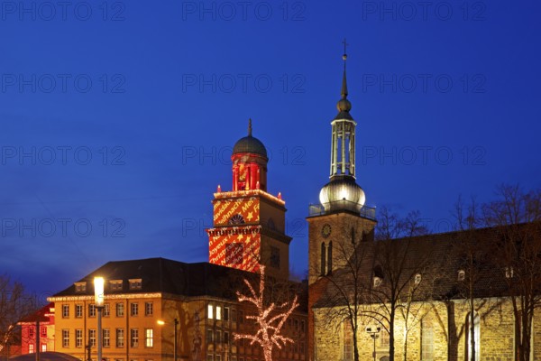 The Christmassy illuminated town hall tower and the illuminated church tower of St. John's Church in Witten, Ruhr area, North Rhine-Westphalia, Germany