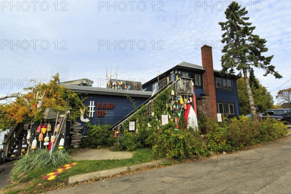 Colorful lobster buoys, decoration at former fishing lodge, seafood restaurant, lobster specialty, Perkins Cove, picturesque fishing village in Ogunquit, Maine, New England, USA