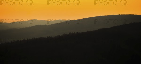 Silhouettes of mountains at sunset with orange sky, Vadsö, Finnmark, Norway