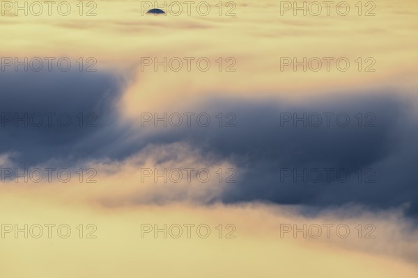 View from Mount Domen. Thick sea fog hangs over the Barents Sea and the midnight sun shines in an orange sky in the north. A dome of the NATO radar station in Vardö rises through the fog., Domen, Vardö, Finnmark, Norway