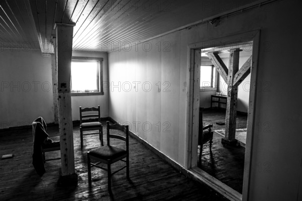An empty interior of a house, black and white, with old wooden floors and a few chairs, Vardø, Finnmark, Norway