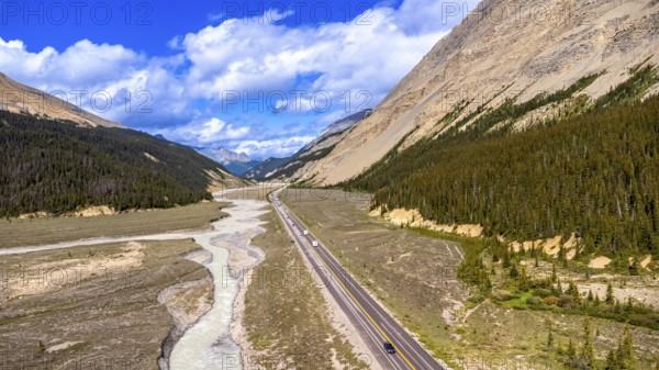 Aerial view capturing the icefields parkway winding through the valley shaped by athabasca glacier in jasper national park, alberta, with sunwapta river flowing alongside