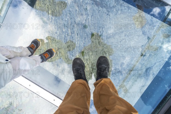 Tourists are enjoying the breathtaking view from the glass floored skywalk. Overlooking the athabasca glacier in jasper national park. Alberta. Canada. A thrilling experience of nature's icy wonders