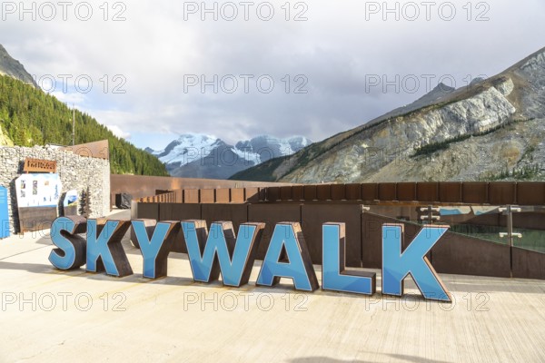 Welcoming sign marking the glass floored skywalk over sunwapta valley, with the athabasca glacier and majestic mountains in jasper national park, alberta, canada