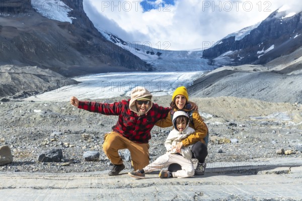 Happy family posing for a photo in front of the breathtaking athabasca glacier in jasper national park, embracing the beauty of the canadian rockies during a memorable vacation