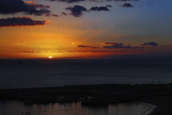 Dramatic sunset over the ocean with intense colors in the sky, Los Cristianos, Tenerife