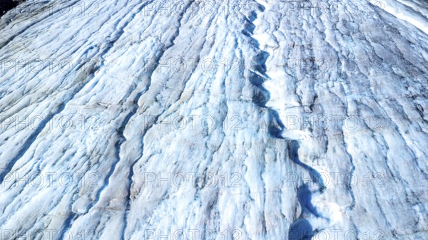 Melting glacial ice flowing down the athabasca glacier reveals stunning blue crevasses, highlighting climate change's impact on jasper national park in alberta, canada