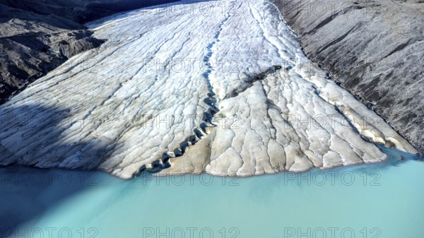 Athabasca glacier, part of the columbia icefield, is melting into a vibrant turquoise lake, highlighting the effects of climate change in jasper national park, alberta, canada