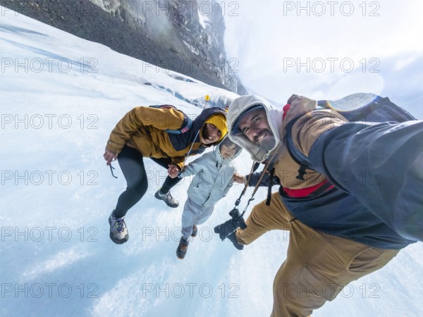 Happy family taking a selfie while standing on the athabasca glacier in jasper national park, enjoying their vacation surrounded by breathtaking natural beauty