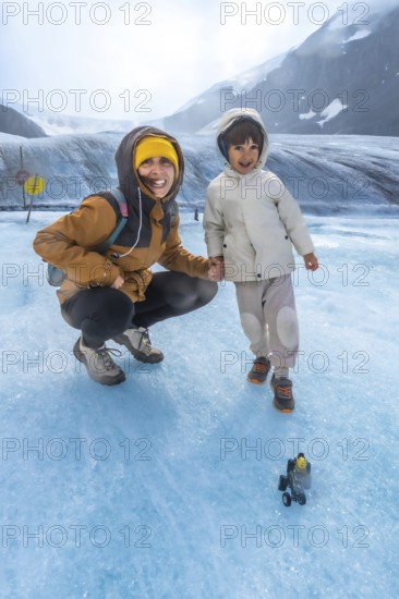 Mother and her child are enjoying a memorable adventure on the athabasca glacier, surrounded by the breathtaking scenery of the canadian rockies in jasper national park, alberta, canada