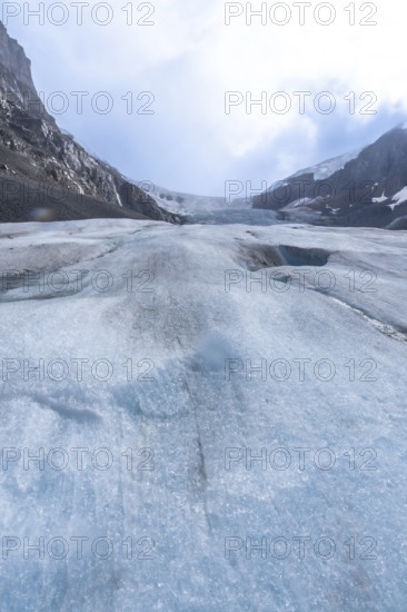 Athabasca glacier is showing signs of melting and receding, revealing the underlying terrain and highlighting the impact of climate change on the canadian rockies