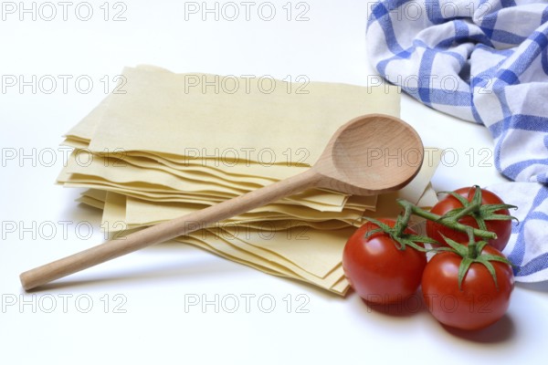 Lasagna, dried lasagna leaves with tomatoes and cooking spoon
