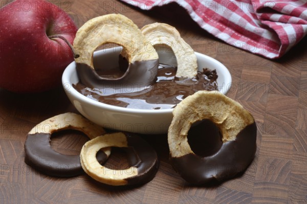 Apple rings, coated with chocolate, chocolate glaze in bowl