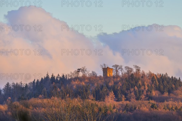 Hill with the tower of Diedrichsburg, surrounded by forests, under a pastel-colored sky in the morning light, Meller Mountains, Melle, Lower Saxony, Germany