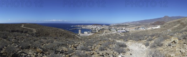 Panoramic view of the tourist town of Los Cristianos with the sea in the foreground and mountains in the background, Los Cristianos Tenerife