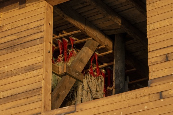 A wooden building with drying fishing nets illuminated by sunlight, Vardø, Finnmark, Norway