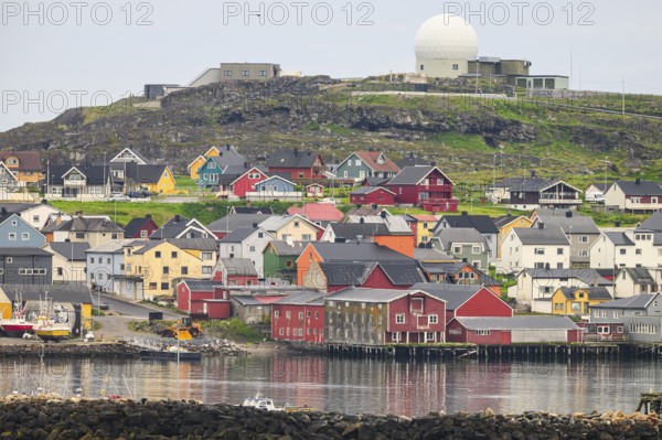 City view of Vardö with NATO radar dome, colorful coastal town with houses on the water, overlooked by hills, Vardø, Finnmark, Norway