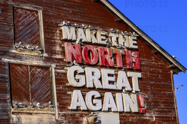 Red fishing building with the inscription Make the North great again at Vardö harbour, Vardø, Finnmark, Norway