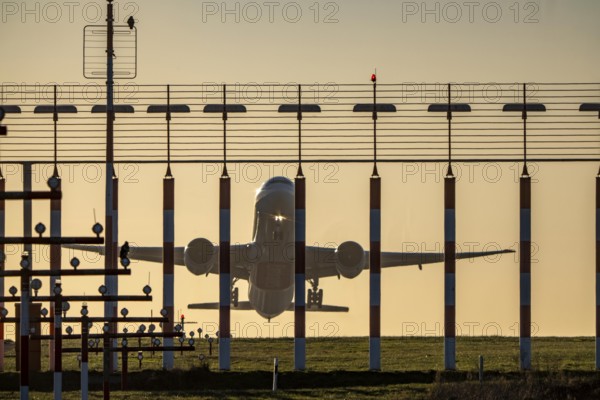 Runway lighting, approach aids, at Düsseldorf International Airport, sunset, aircraft taking off, Hauptbahn Süd, 05R/23L, Emirates Boeing 777, North Rhine-Westphalia, Germany
