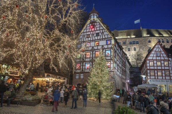 Christmassy illuminated square with the historic Pilate House with advent calendar, in the evening lighting, the Kaiserburg in the back, Beim Tiergärtnertor, Nuremberg, Middle Franconia, Bavaria, Germany