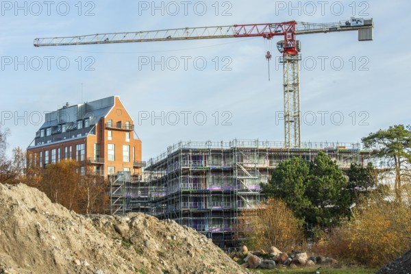 Construction site with completed high-rise building, house under construction and construction crane in Ystad, Skåne County, Sweden, Scandinavia