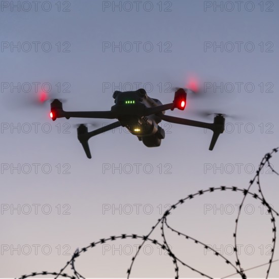 Symbolic picture, drone flying just over barbed wire, airport, threat, espionage