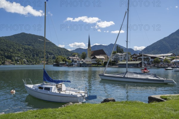 View from Malerwinkel of the village with parish church of St. Lawrence, two sailboats in the foreground, Rottach-Egern, Upper Bavaria, Bavaria, Germany