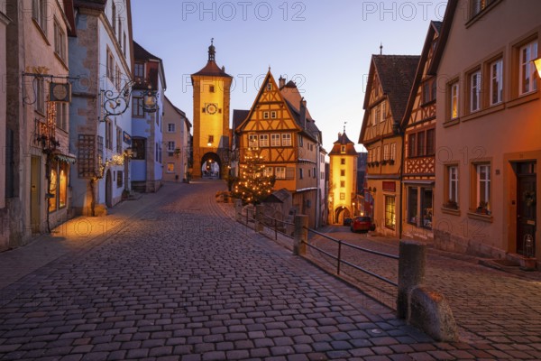 December 25, 2025: Christmastime at Plönlein — Rothenburg ob der Tauber, Bavaria, Germany. Festive Christmas tree and city lights at the blue hour