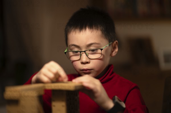 Boy, 6 years, glasses, multi-ethnic, plays concentrated, constructs, builds, Stuttgart, Baden-Württemberg, Germany