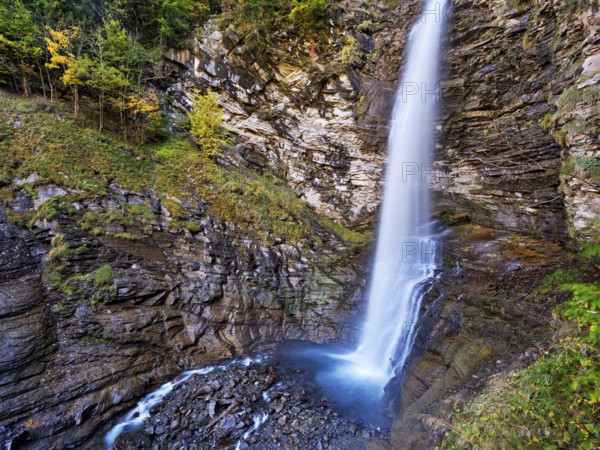 Diesbach waterfall in autumn-colored surroundings, Linthal, Klausenpass, Canton of Glarus, Switzerland
