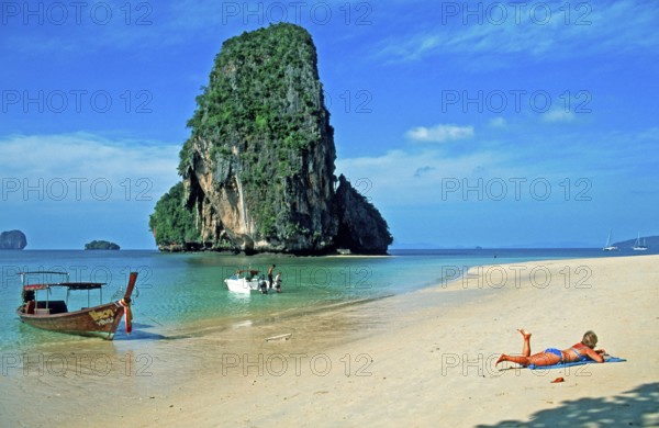 Rocks in the sea, people and longtail boat on Pranang Cave beach, two years in front of the tsunami, Krabi, Thailand, December 2002, vintage, retro, old, historic