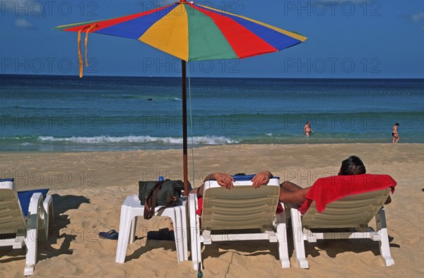 People holding umbrellas and sun loungers on Karon Beach, two years in front of the tsunami, Ko Phuket, Thailand, December 2002, vintage, retro, old, historic