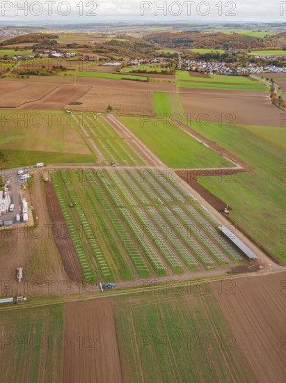 Wide fields with a solar park in the countryside, adjacent to a small village community, energy transition, construction of PV open space, Baden-Württemberg, Germany