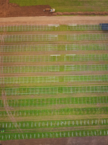 Aerial view of green fields with beginning solar plant construction and agricultural patterns, energy transition, construction of PV open space, Baden-Württemberg, Germany
