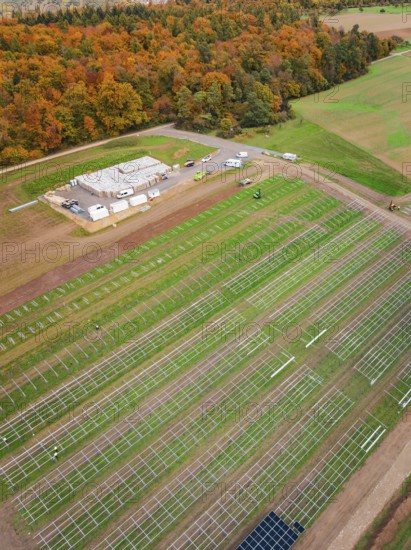 Rural plant for solar installation with adjacent forest in autumn colors, energy revolution, construction of PV open space, Baden-Württemberg, Germany