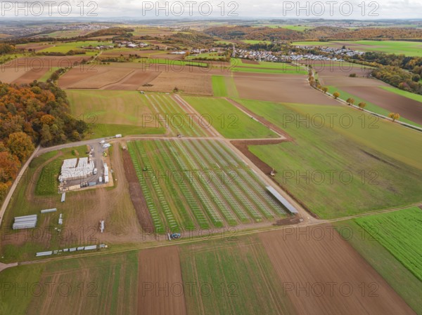 Panoramic view of fields with a solar park and an adjacent small village, Energiewende, construction of PV open space, Baden-Württemberg, Germany